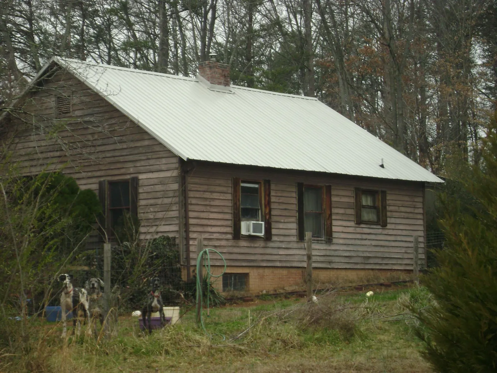 White metal roof on an old wood sided farmhouse, from a Metal Roof Installation job in Patton